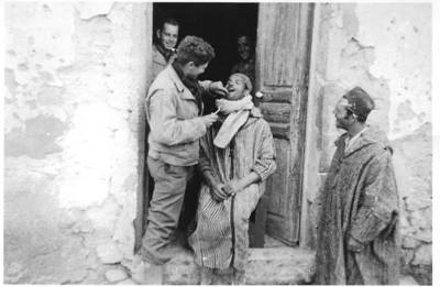 March 1943, Sbiba, Tunisia: "Capt.  Schiffrin, one of our dentists, pulling an  Arab's tooth in front of our aid station at  Sbiba, Tunisia, during a quiet time." Many Medical Assistants were dentists.