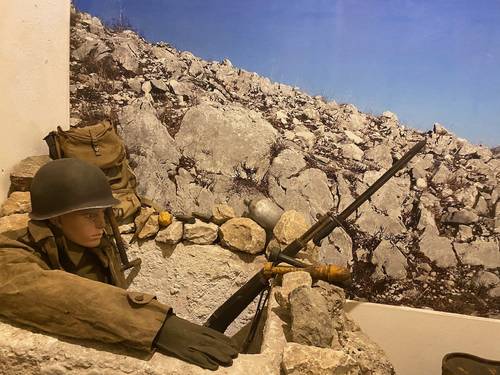 Simulation of an American soldier in his foxhole, often made of rocks.