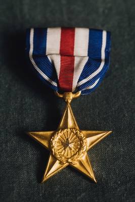 As part of the 34th Infantry Division (133rd/168th Regiments), Ludwick insisted on serving as far forward as possible to ensure that wounded soldiers were quickly treated where they fell and properly evacuated. 	As a result, he earned the Purple Heart in Tunisia and was decorated with the Silver Star in Italy, where during the bloody battle of Monte Pantano, the treatment and evacuation of the wounded had been slowed under intense enemy fire.  For five days he made frequent trips to the battlefield to not only supervise and coordinate the treatment and evacuation of the heavy casualties, but to administer aid to the wounded, himself.  “Due to his initiative and tireless efforts, many lives were saved that otherwise might have been lost,” reads the official commendation. “Major Ludwick’s courage and bravery were highly meritorious and a credit to the Armed Forces of the United States.”