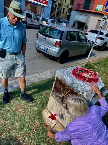 Placing a red poppy at the base of the 34th Infantry “Red Bull” Division’s plaque in the town square. 