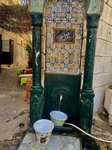 One of 5 potable fresh water stations in the Casbah where residents can get water. There is no running water in homes. Women fill many buckets of water every day. The water comes from a well.